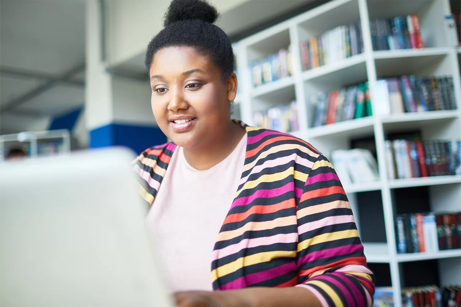 Image of a student facing an open laptop.